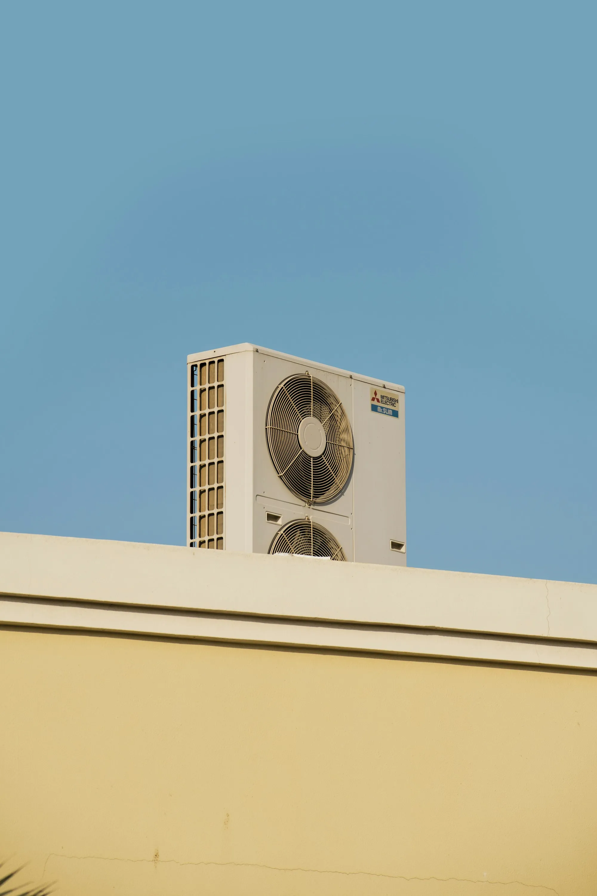 Rooftop condenser unit against a clear blue sky